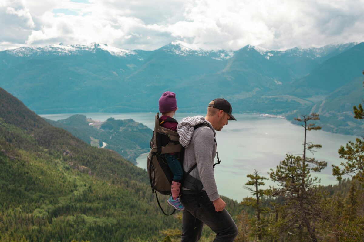 A father climbing a mountain with his child on his back