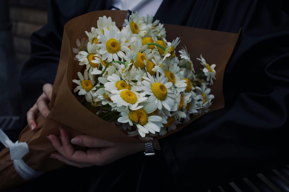 Man in suit holding kraft paper bouquet
